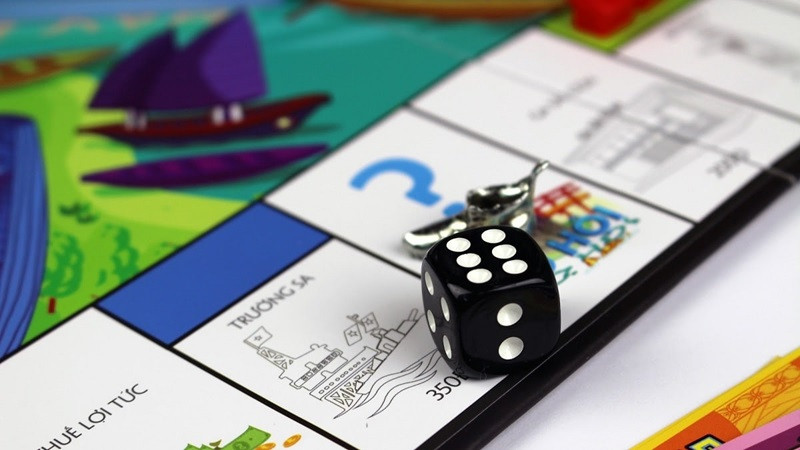 Người chơi đang tương tác với tiền và thẻ tài sản trên bàn cờ Monopoly