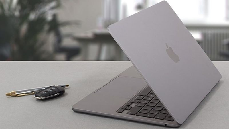 Người dùng đang làm việc với MacBook Air mỏng nhẹ tại quán cà phê, nhấn mạnh tính di động cao