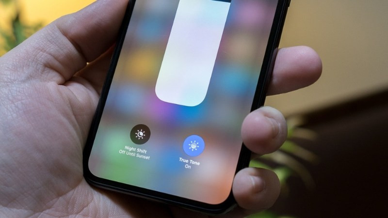 Người dùng thư giãn đọc sách hoặc sử dụng tablet trong không gian thoải mái, minh họa lợi ích của True Tone