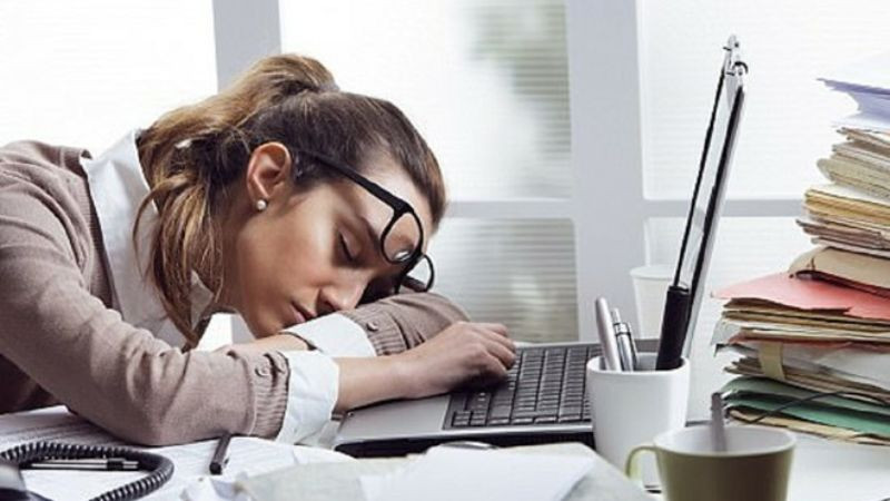 Người lớn ngủ gật trên bàn làm việc, biểu cảm mệt mỏi chân thực