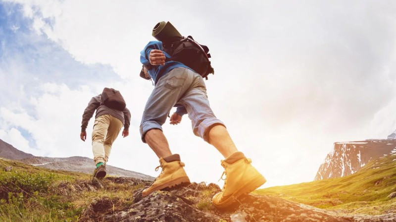 Người tham gia trekking đứng nhìn ra phong cảnh thiên nhiên hùng vĩ từ trên cao, thể hiện lợi ích khám phá