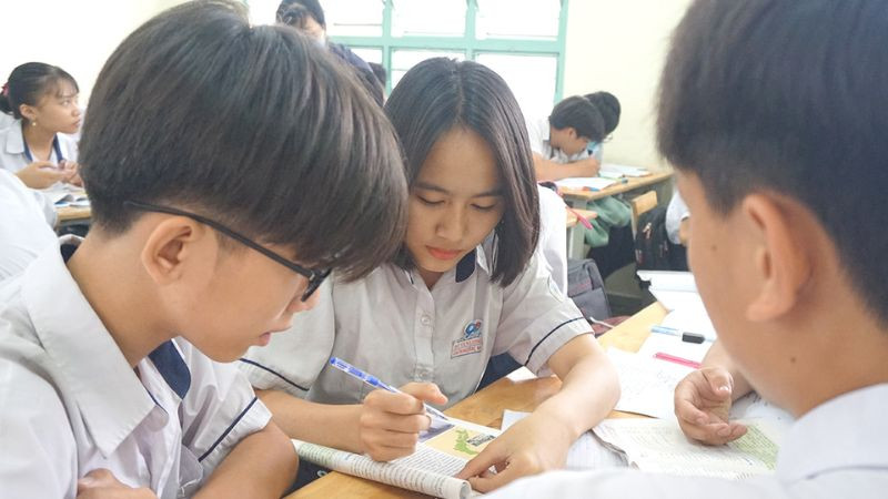 Người trẻ tập trung viết ghi chú vào sổ tay