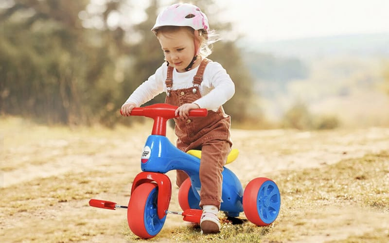 Nhóm trẻ đang chạy nhảy và chơi đùa ngoài trời, thể hiện vận động thô.