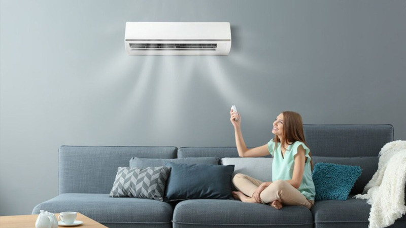 Tay người sử dụng điều khiển điều hòa, nhấn nút Mode để chuyển sang chế độ Auto, biểu thị sự tiện lợi khi máy tự động hoạt động