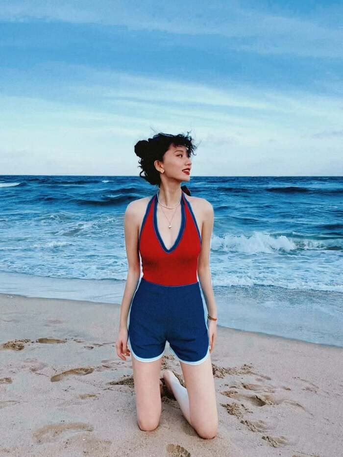 Thiếu nữ mặc bikini dạo bước trên bãi cát biển