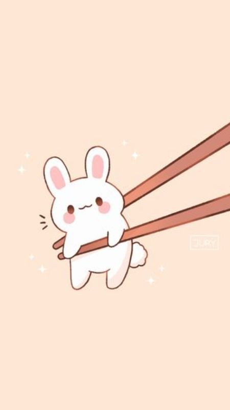 Thỏ đáng yêu nhỏ xíu được đôi đũa gắp giữ lại trong hình ảnh cute
