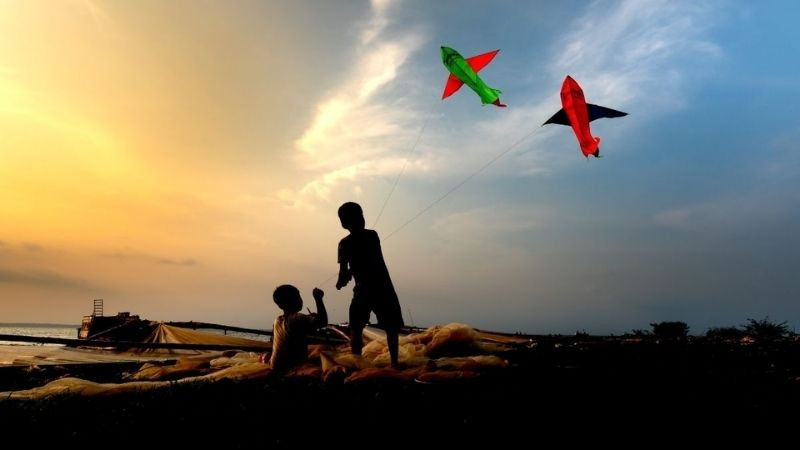 Trẻ con thả diều khi mặt trời sắp lặn