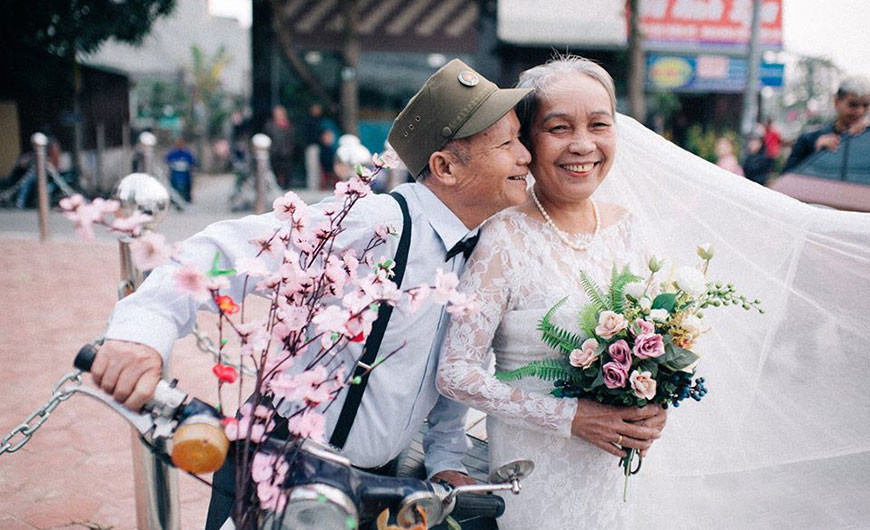 Vợ chồng già chụp ảnh kỷ niệm ngày cưới trong không khí Tết