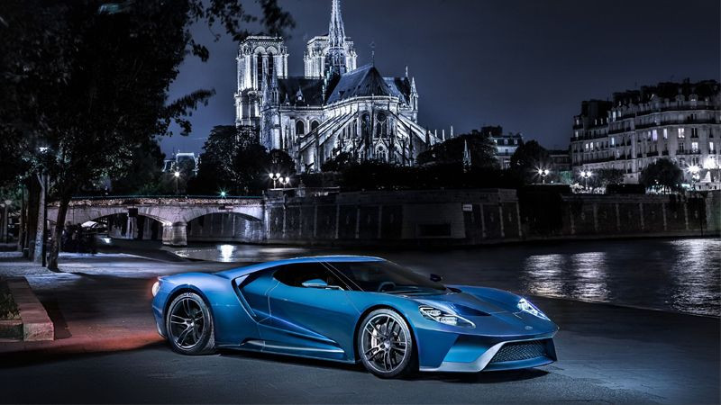 Xe thể thao màu xanh dương đậu bên hồ vào ban đêm