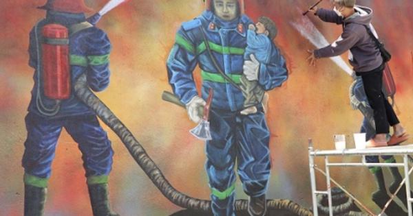 Bức tranh vẽ những người lính cứu hỏa đang dũng cảm chiến đấu với ngọn lửa để cứu người và tài sản