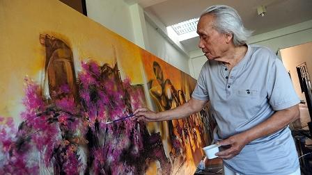 Họa sĩ tập trung sáng tạo trong xưởng vẽ, thể hiện niềm đam mê nghề họa sĩ.