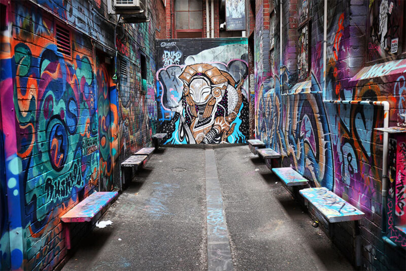 Nghệ thuật đường phố: Định nghĩa và các loại hình Nghệ sĩ đang tạo ra tác phẩm graffiti trên bức tường, minh họa nghệ thuật đường phố truyền thống